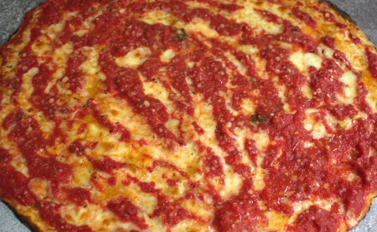 Philadelphia Trenton-style tomato pie topped with tangy tomato sauce and grated cheese on a thick, crisp crust.